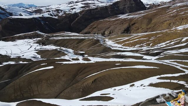 aerial view of Langza Buddha Statue in kaza spiti valley drone revealing scenic mountains landscape 