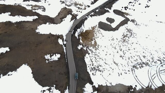 aerial top down car driving in world's highest village hikkim in spiti valley in himachal pradesh India winter snow landscape 