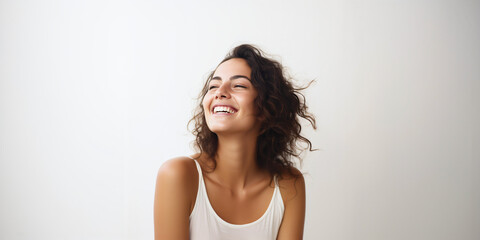 Fototapeta premium laughing woman with long dark hair in white top isolated on clean background