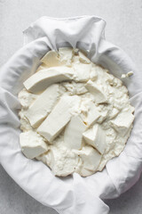 Greek yogurt being strained in white cotton cloth, process of making Greek yogurt, strained yogurt in white cotton napkin