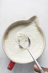 Greek yogurt in a white bowl, process of making Greek yogurt, strained yogurt in ceramic white bowl