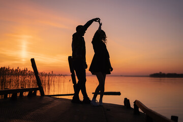 Couple dancing at sunset salsa / brazilian zouk. Lovers, dance partners spinning, latin festival...