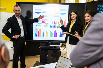 Group of  business people presenting business graphic on screen in business conference room