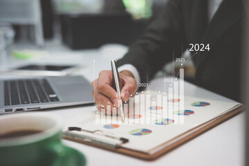 Businessman analyzes profitability of working companies with digital augmented reality graphics, positive indicators in 2024, businessman calculates financial data for long-term investments.
