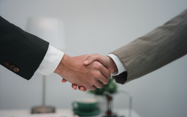 Recruiter shaking hand with candidate in office
