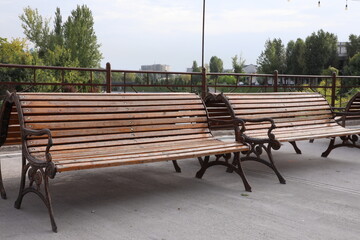 Wooden benches in the city park. Park bench on the street.