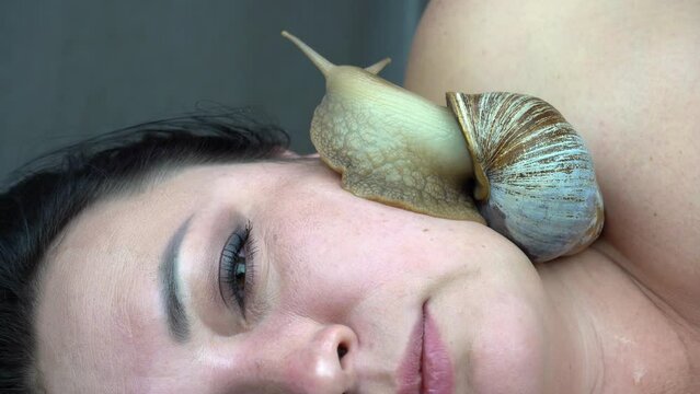 Skin care with mucin. Cosmetological procedure, snail crawling on the face 