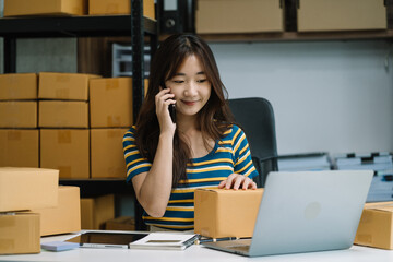 young asian women using smartphone contacted a customer asking for a shipping address.