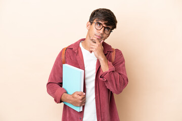 Young student caucasian man isolated on ocher background having doubts