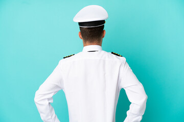Airplane caucasian pilot isolated on blue background in back position
