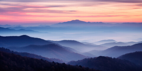 The mountains are shrouded in mist, and the last traces of daylight lend a tranquil, mystical quality to the scene. A twilight shot of autumn mountains under a fading pink and purple sky. - Powered by Adobe