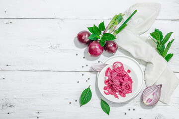Jar with tasty pickled onions on black table. Cutlery, served meal ready to eat, trendy stand