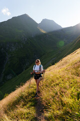 Girl with a backpack hiking in the evening light