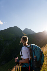 Girl with a backpack hiking in the evening light