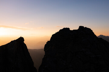 Silhouette of a person watching the sunrise on a mountain top