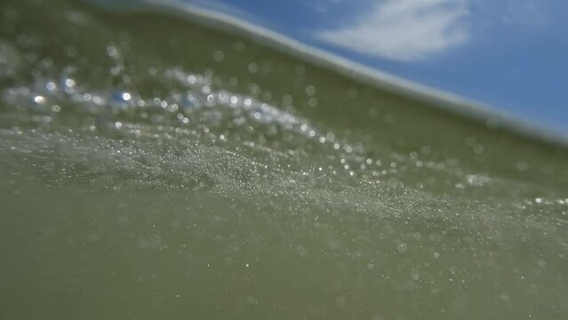 Dive deep and then reappear above the shimmering sea, a slow-motion journey amidst sun and soft waves.