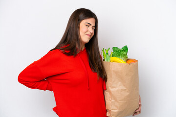 Young Brazilian woman holding a grocery shopping bag isolated on white background suffering from backache for having made an effort