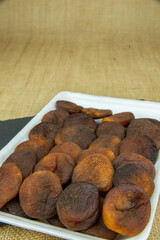 Sun dried apricot on rock plate in white foam