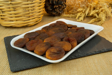 Sun dried apricot on rock plate in white foam