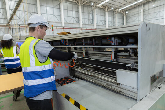 Staff worker man using Compressor Air Blow Gun cleans dust in machine. Male working cleaning machine hard to reach area.