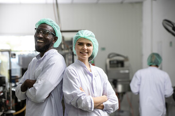 Portrait happy black worker laugh smiling together with woman friend standing arm crossed working in food and drink factory with hygiene