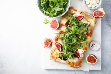Homemade pizza with figs and arugula - obrazy, fototapety, plakaty