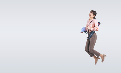 ヘルメットを持ってジャンプするミドル女性（切り抜き背景透過PNGも販売しております。作成者リンクから「PNG」で検索してください）