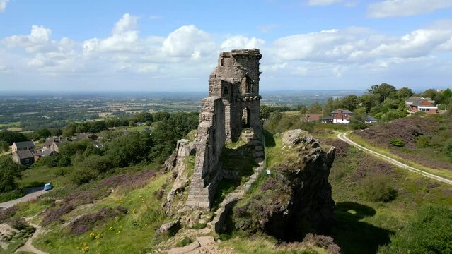Circling and pass through archway of an abandoned castle folly on a hill 