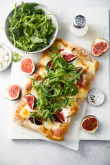 Homemade pizza with figs and arugula