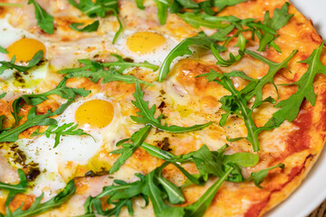 Margarita pizza with arugula and egg for breakfast, selective focus