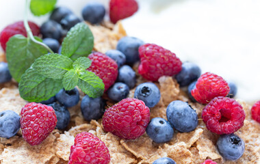 Whole wheat granola breakfast with organic blueberries and raspberries. Close up