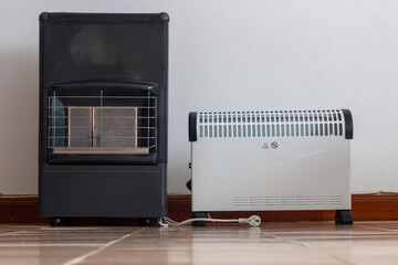White electric resistance stove or radiator for domestic use and next to it a catalytic stove...