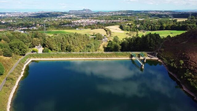 Edinburgh cityscape and reservoir aerial view. Torduff reservoir is located in Pentland Regional Park, Bonaly, Scotland