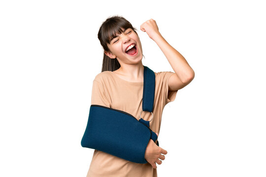 Little caucasian girl with broken arm and wearing a sling over isolated background celebrating a victory