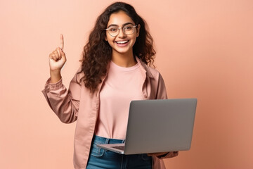 Young college girl using laptop and pointing on up side - obrazy, fototapety, plakaty