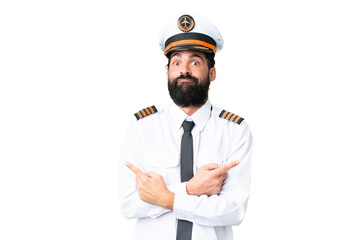 Airplane caucasian pilot man over isolated chroma key background pointing to the laterals having...