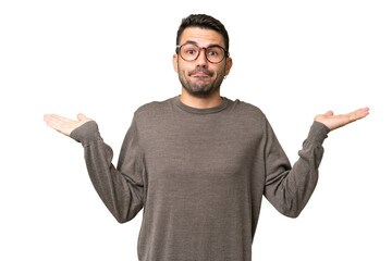 Young handsome caucasian man over isolated background having doubts while raising hands
