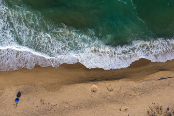 Aerial view of secluded beach with a beach umbrella