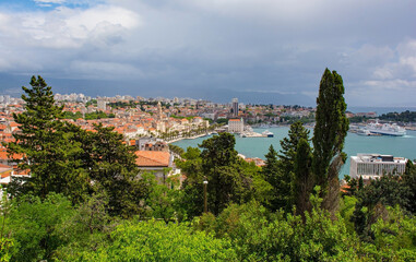 Fototapeta na wymiar A view of the historic coastal town of Split in Croatia from Marjan Hill which overlooks the town, Cruise ships and ferry boats can be seen in the harbour area far right