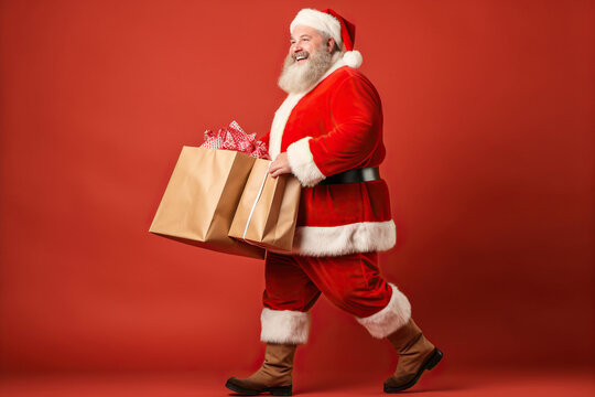 Full Length Body Size Profile Side View Of His Nice Fat Overweight Cheerful Glad Santa Carrying Bags Gifts Isolated Over Red Color Background