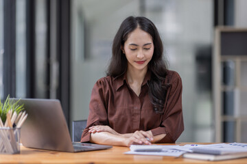 Young attractive business asian woman checking searching document  her project with laptop computer in the office room.