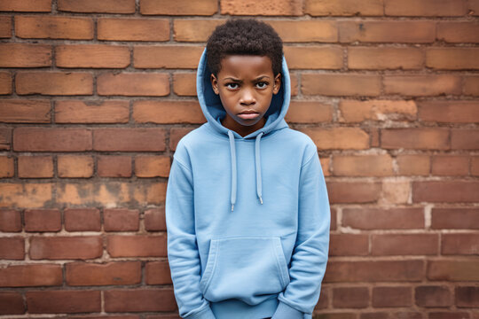 Sadness African Boy In Blue Sweatshirt On Brick Wall Background
