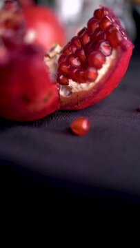 Vertical video of ripe Israeli pomegranate with seeds for the Jewish New Year on the black background