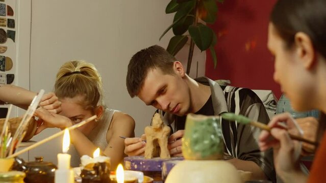 Burning candles at the modeling clay workshop add to the atmosphere. The participants focused on the products made from clay. High quality 4k footage