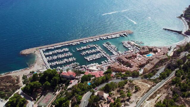 Aerial drone footage of Mascarat marina, small bay or port with private sailing boats and yachts. Mascarat gated community near Altea Hills, Costa Blanca, Spain. Summer holiday destination