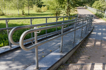 Concret ramp way with stainless steel handrail for support wheelchair disabled people. High quality...