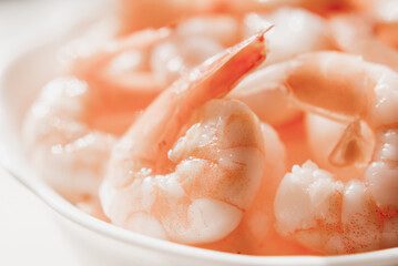Peeled shrimps in a bowl isolated on white background. Top view