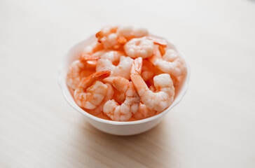 Fototapeta na wymiar Peeled shrimps in a bowl isolated on white background. Top view