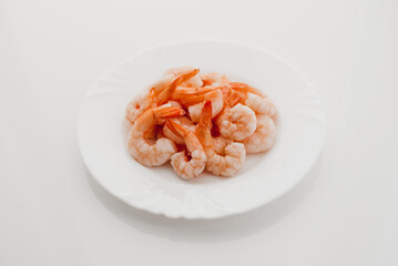 Peeled shrimps in a bowl isolated on white background. Top view