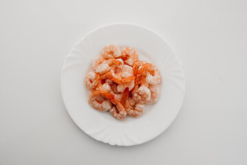 Peeled shrimps in a bowl isolated on white background. Top view